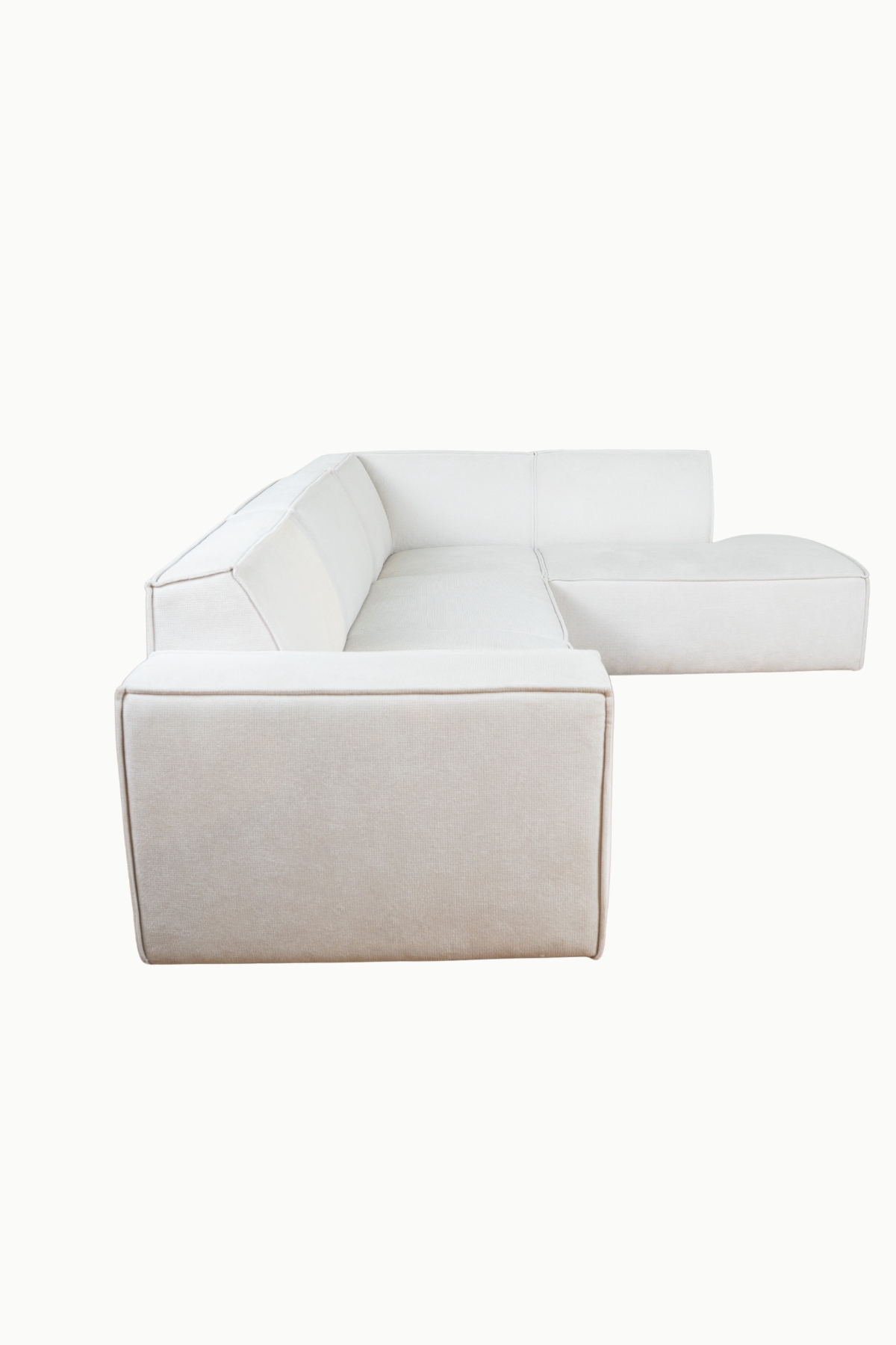 Canapé magnum en tissu chenille écru, modèle d’angle avec assises larges et lignes épurées