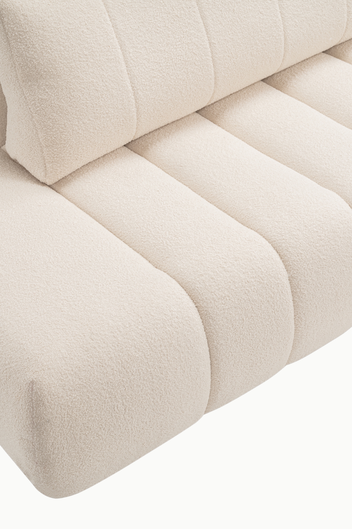 Canapé d’angle Baloo coffre et convertible en laine bouclée écrue, assises larges à coutures verticales, dossier confortable et méridienne, design arrondi moderne.