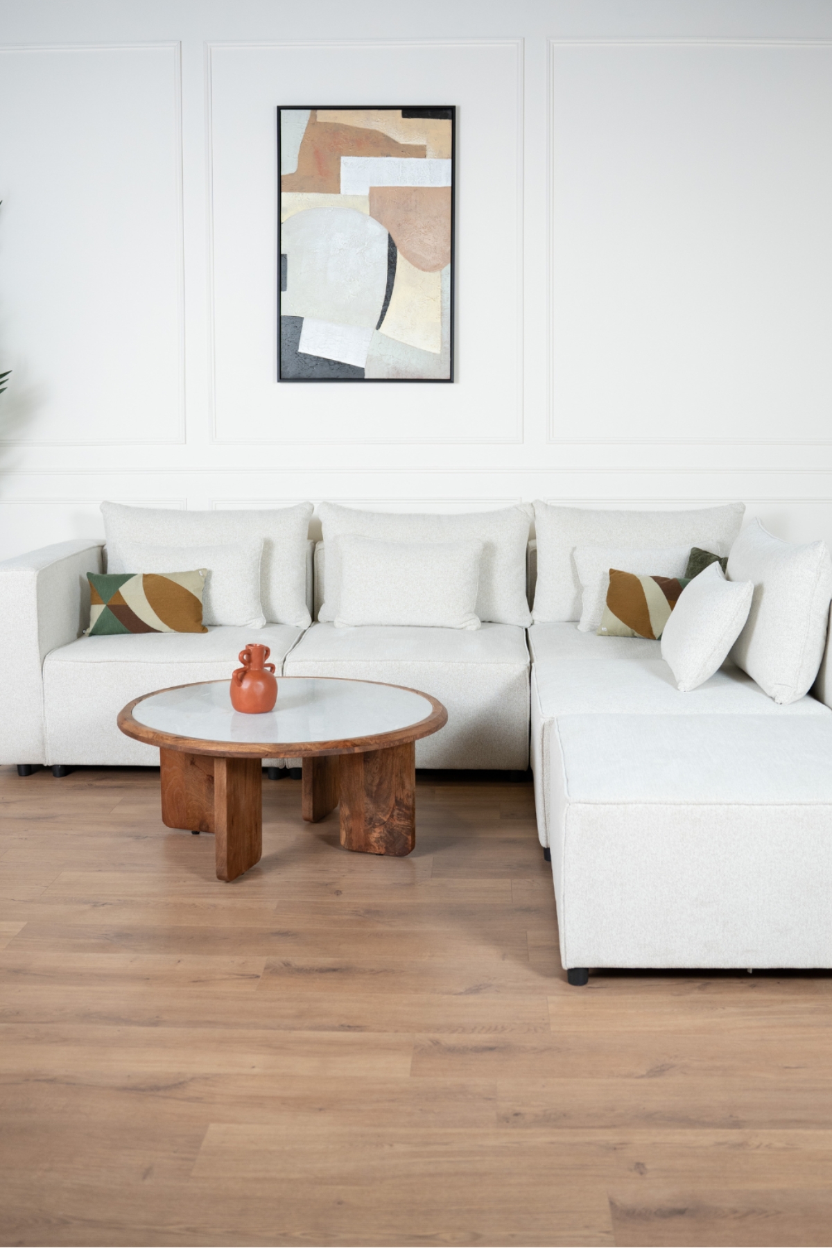 Canapé d'angle modulable en tissu chenille écru, composé de plusieurs modules avec coussins assortis"