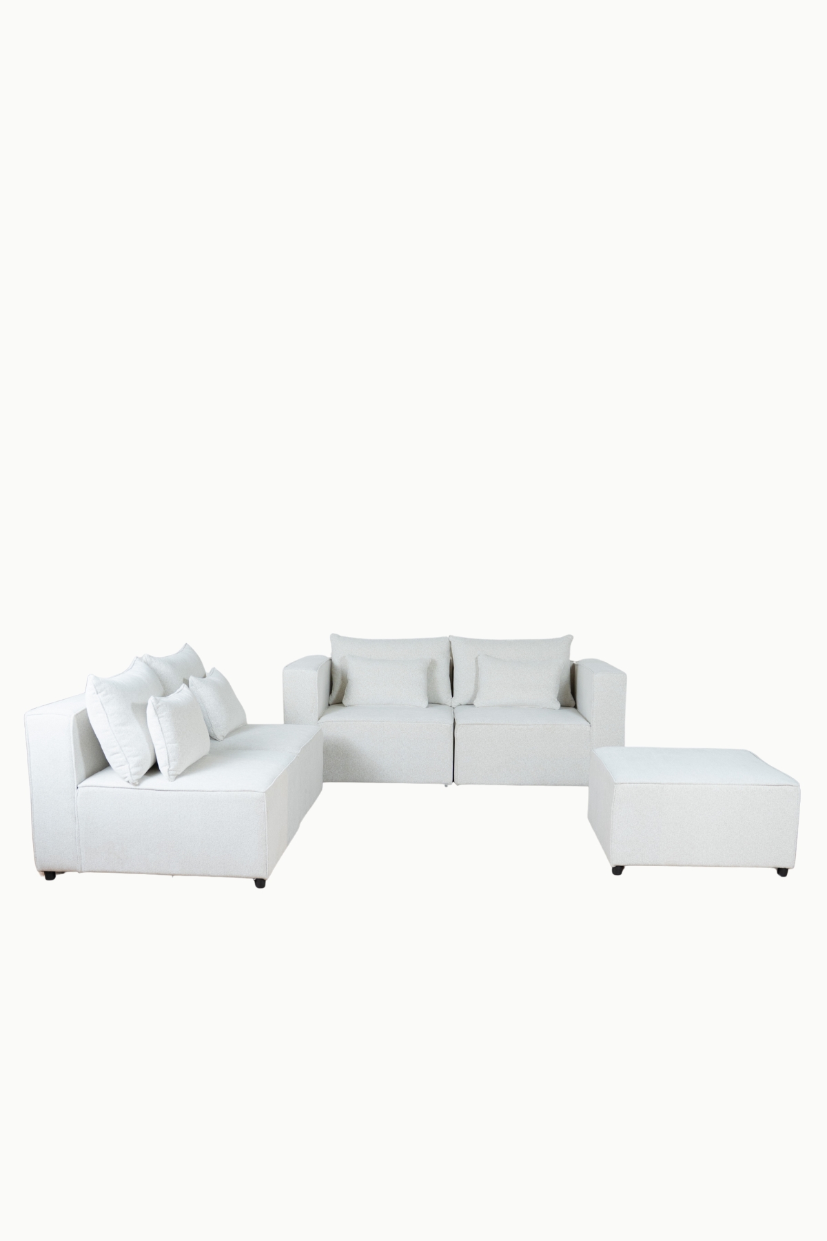 Canapé d'angle modulable en tissu chenille écru, composé de plusieurs modules avec coussins assortis"